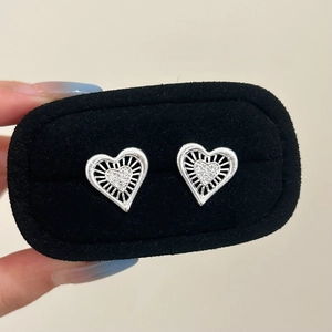 Minimalist silver heart stud earrings featuring a hollow radial design and pavé crystals