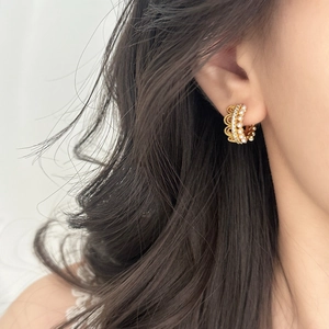 French lace style gold C-hoop earrings with pearls and crystals worn on brown hair