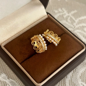 Detail of French lace gold earrings with small white pearls and crystals in a velvet box