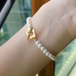 Detailed view of freshwater pearl necklace featuring a golden floral OT toggle clasp