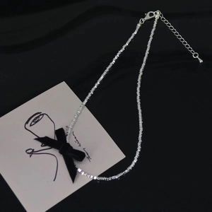 Silver bead necklace featuring a black velvet bow with adjustable chain lobster clasp