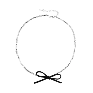 Minimalist silver beaded choker necklace featuring a black velvet bow and adjustable chain