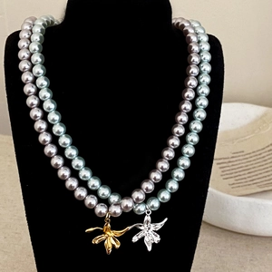 Collier de perles élégant avec pendentif de lys en finitions or et argent