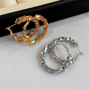 Disco-style geometric hoop earrings set in gold and silver with sparkling metal textures