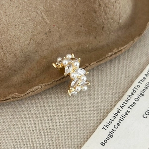 Gold leaf-shaped ear cuff featuring elegant white pearls and marquise cut cubic zirconia