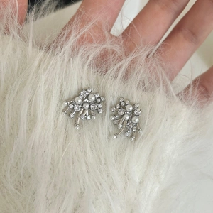 Detail of silver firework stud earrings featuring round pearls and sparkling crystals