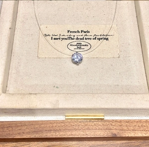 Detail view of a sparkling zircon pendant with a floating invisible chain in a jewelry box