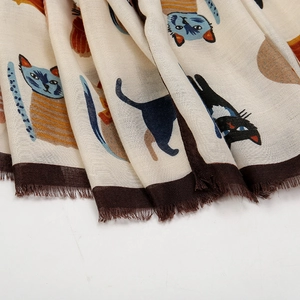 Detail of printed scarf with cartoon cat pattern and dark brown fringed edges