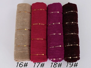 Detailed texture of sequined lace scarves in gold, rose, purple and burgundy colors