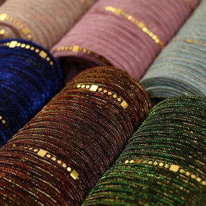 Detail of sequined lace scarf with metallic threads and gold square glitter accents