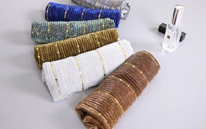 Detailed view of sequin lace scarves in navy, cyan, bronze, silver, and copper tones