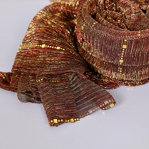 Macro shot of sequins and metallic stripe texture on a crinkled lace scarf
