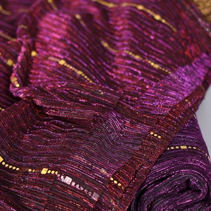 Detail of purple pleated scarf fabric with shimmering gold threads and sequins