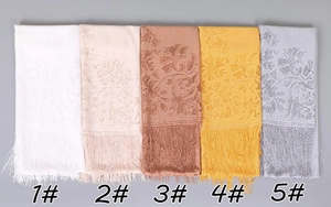 Detail view of five lace shawls with floral jacquard patterns and elegant fringe tassels