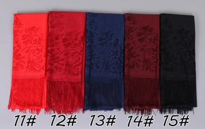Detailed view of lightweight jacquard floral scarves with long tassels in multiple colors