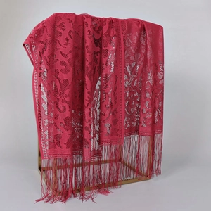 Close-up of rose red lace shawl with floral patterns and long fringe tassels