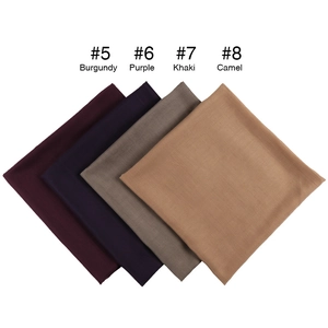 Flat lay of square scarves in Burgundy, Purple, Khaki and Camel showing fabric texture