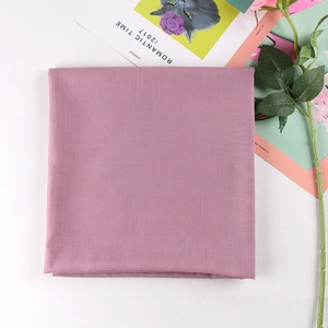 Flat lay of folded lavender square scarf on white background with floral decor