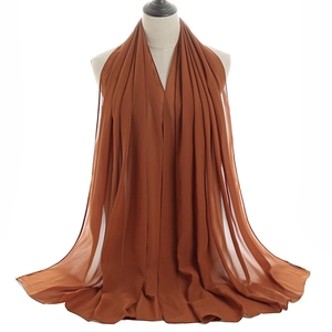 Detail of caramel pleated chiffon shawl showing breathable fabric texture and drape