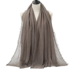 Brown crinkle cotton linen scarf with frayed edges displayed on a half-body mannequin