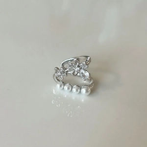 Détail de la bague double couche argentée avec fleurs en diamant et perles blanches