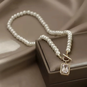 Detailed view of pearl necklace with gold OT toggle clasp and square zircon pendant