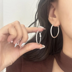 Detail of matte silver hoop earrings shown worn and held to display large classic round design