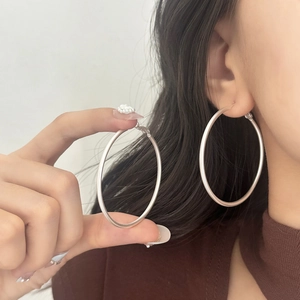 Silver matte hoop earrings shown on model with 5-6cm diameter and minimalist design