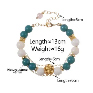 Detail of beaded multilayer bracelet with natural stones and gold flower charm