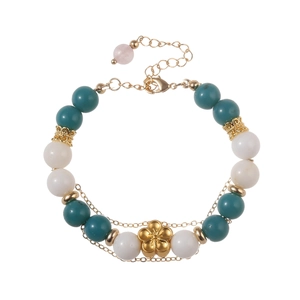 Modern beaded bracelet with light green stones and a golden floral charm pendant