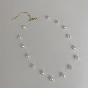 Close-up of elegant pearl necklace with invisible fishing line and gold lobster clasp