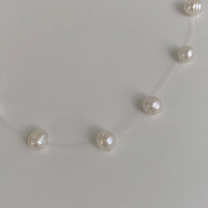 Elegant floating pearl necklace featuring cream freshwater pearls on invisible fishing line