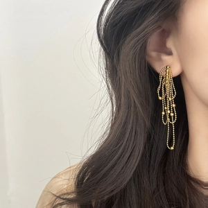 Elegant gold multi-strand tassel drop earrings on model in minimalist style