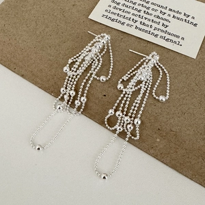 Close-up of elegant silver beaded tassel earrings with shimmering metallic luster