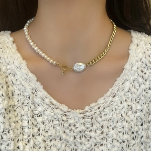 Detail of baroque pearl necklace with asymmetrical gold Cuban chain on model