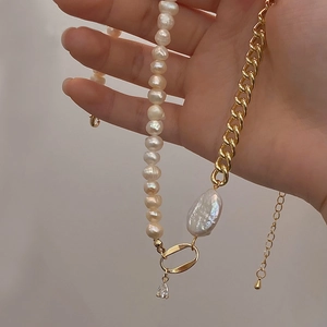 Handheld view of French baroque pearl necklace with gold plated chain and zircon pendant