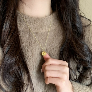 Elegant gold-plated geometric rose pendant necklace on a delicate chain worn by model