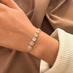 Elegant gold-plated halo tennis bracelet with round clear crystals on silk fabric