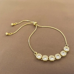 Detail of adjustable gold bracelet with six square-cut zircon stones and snake chain