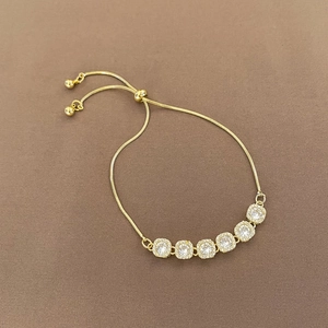 Detailed macro view of adjustable gold bolo bracelet with sparkling zircon square charms