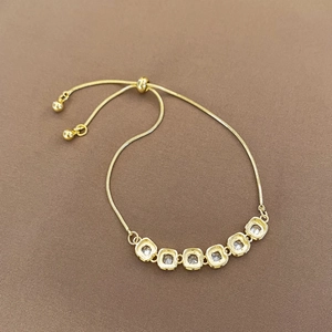 Detail of adjustable gold snake chain bracelet with six bezel-set square zircon stones