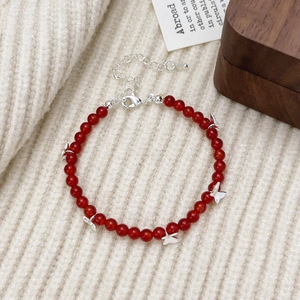 Detail of red agate bead bracelet featuring silver butterfly charms and lobster clasp