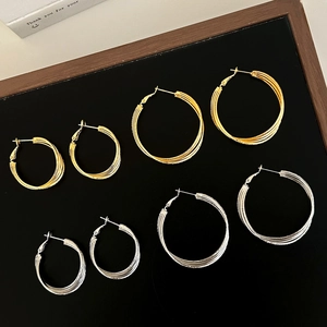 Multi-layered Mobius hoop earrings in gold and silver finish with spiral texture