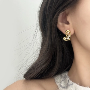 Elegant gold hollow heart earrings with white zircon accents worn by a model