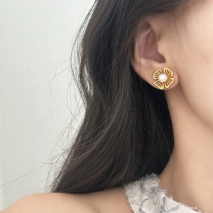 Orecchini a fiore traforato stile francese con perle bianche indossati da una modella