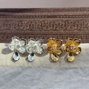 Elegant floral stud earrings set in gold and silver finish with crystal center