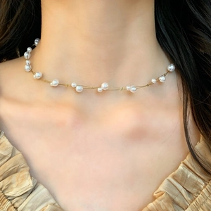 Elegant gold choker necklace with delicate white pearls for a minimalist French style look