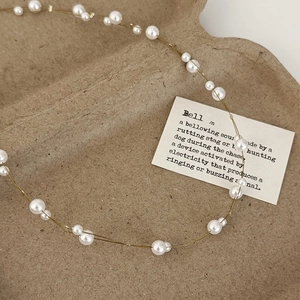 Detail of elegant pearl necklace with gold wire on vintage textured background