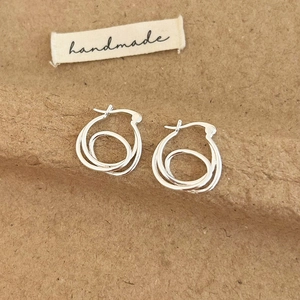 Close-up of S925 sterling silver interlocking double hoop earrings on craft paper