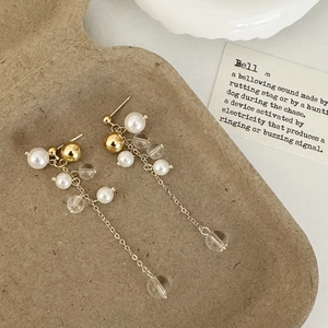 Detailed close-up of French vintage long tassel earrings with pearls on a rustic card